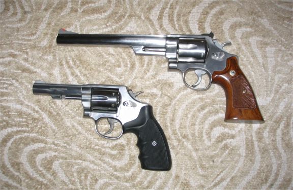 These are my revolvers. The picture is not precisely to scale as comparedto the semi-autos in the other picture, since the camera was at a sligtlydifferent distance. On the upper right is the .44 Magnum, and below thatis the .357 Magnum. Both are Smith & Wesson. The .44 has an 8 3/4" barrel, as compared to the 4" barrels on my Sigs inthe other picture.