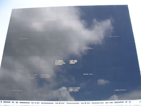 This is the large Astronaut Memorial. It's actually a black-colored stone, but veryglossy. The reflection of the sky and clouds disguises the color. The lettering isengraved in a golden color. Click the picture for the full-resolution raw image (3.2megapixel, 983kb) from my camera, in which you can read the names.