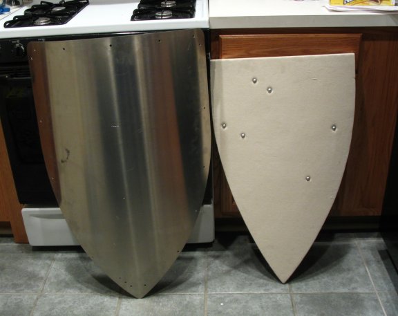 The new shield blanks. The one on the left is an aluminum shield blankintended for SCA combat. The one on the right is a Windlass shield, madeof wood and pre-strapped, and canvas-covered.
