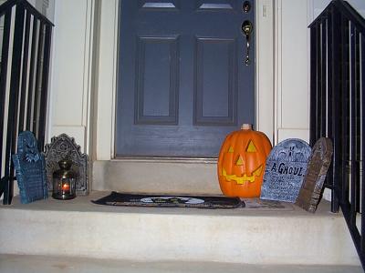 At my front-door, I had a jackolantern, gravestones, and a lantern, aswell as a "Trick or Treat" doormat. When someone would knock, I'd runthe fog machine (which was inside the house) for a few seconds, thenopen the door... it would appear that I was stepping out of a thickmist as I opened the door. :) Unfortunately, the flash washed everything out in this picture. This shot was actually taken at night. With the flashturned off in another picture, nothing came out at all. I wish I couldshow here how creepy this looked under nothing but the lantern-light,and the glow of the illuminated pumpkin. Half the trick to making agood halloween display is correct lighting, which is why I never allowedflash pictures in my old haunted houses.