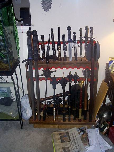 I finally got around to putting this old display rack to use, andput up some of my items that just didn't have a place to stay before.It has my daggers, all but one of the maces, both flails, and my replica pistols. Also present is my newest item, the two-handed mace visible on the rightside of the display. Now that's a great <A href="http://catb.org/~esr/jargon/html/L/LART.html">LART</A>!