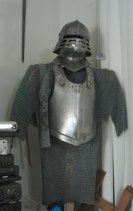 My old steel set of mail. It weighs about the same as my set ofplate armor. Also the old SCA-style sallet, an imported breastplate,and my old "cheater" set of chain can be seen hanging from the shoulder. The cheater-set was basically a chainmail dickie. It's just sleeves andshoulders. I wore that in the interim until my aluminum set was ready,so as to avoid wearing 50 lbs of mail on my shoulders. At least the platedistributes it... this chainmail does not.